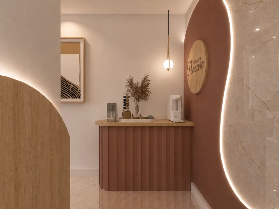 Recepção do Espaço Pensare: balcão de atendimento em terracota canelada, arco com o logotipo em madeira e parede de mármore iluminada.